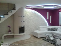 piękny salon z kominkiem, okrągłości, kamień na ścianie, fiolet, sufit ozdobny z podświetleniem