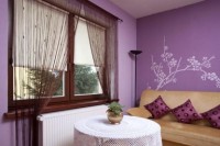 Delikatna dekoracja okienna idealnie współgra z fioletem ścian