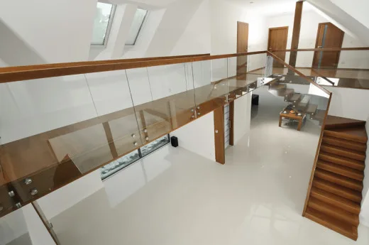 Schody dębowe barwione – konstrukcja dywanowa z balustradą ze szkła hartowanego