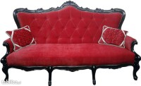 Czerwona sofa rustykalna na drewnianych nóżkach