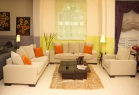 Nowoczesne sofy salonowe – żywy pomarańcz poduszek idealnie kontrastuje z beżem tapicerki sof