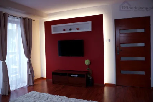 Zabudowa telewizora na ścianie z płyt kartongips z półką nad tv i podświetleniem ledowym