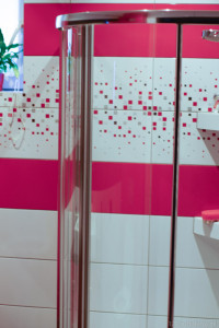prysznic,szklana kabina, różowe płytki , biało różowa łazienka na poddaszu
