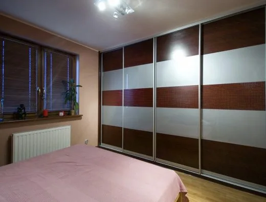 Szafa na całej ścianie w sypialni, drzwi przesuwne